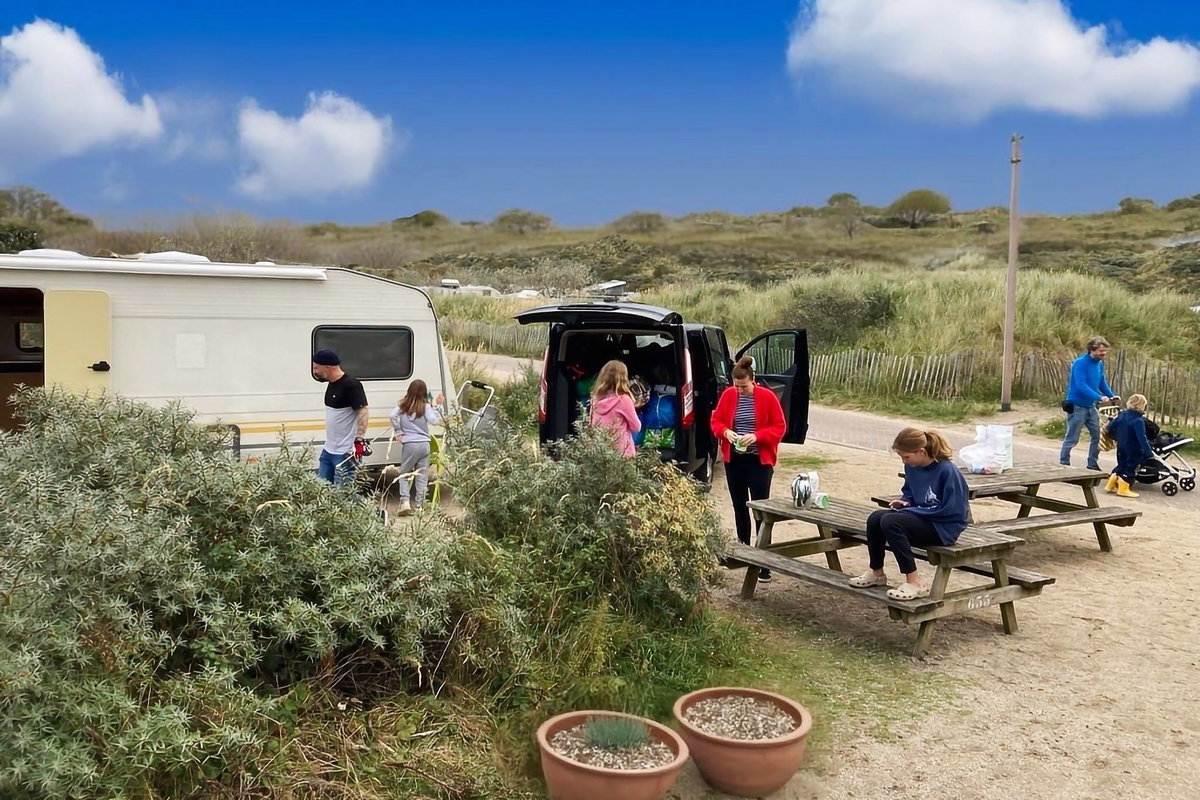 Liste de contrôle : Camping avec enfant - Famille devant caravane au camping
