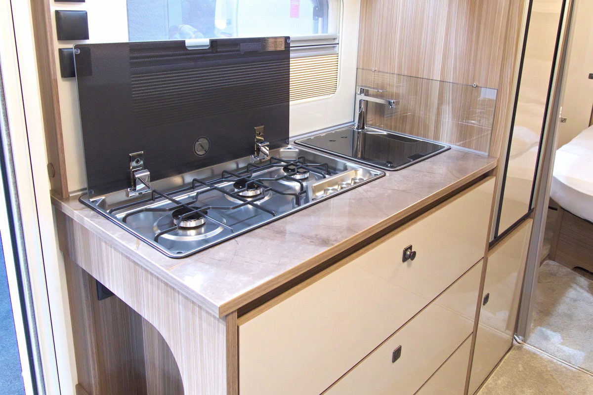 Fendt Tendenza 560 SFDW au Caravan Salon 2026 : bloc-cuisine avec cuisinière à 3 feux, évier, réfrigérateur et rangement.